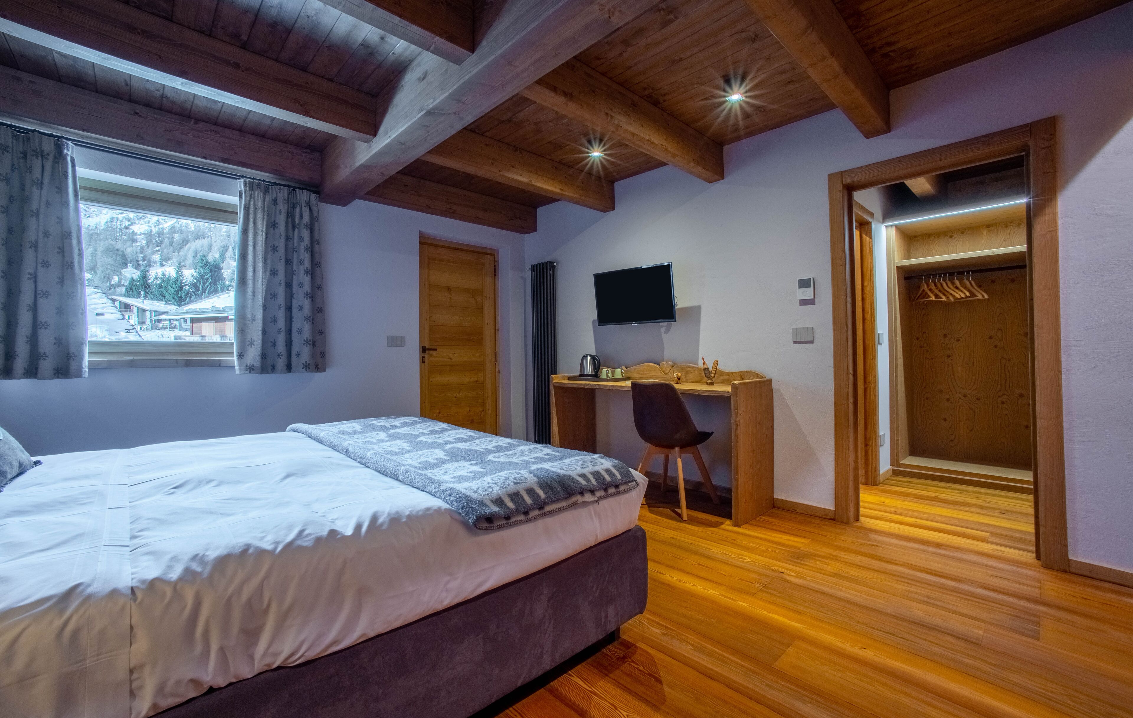 Une chambre à coucher avec un lit, un bureau et un téléviseur.