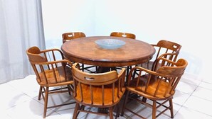 A round wooden dining table with six chairs, a central glass bowl, and a white curtain in the background. - Exclusive apartment in Mxl 3 (Mexicali)