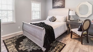 A bedroom with a bed, a chair, a desk, and a painting on the wall. - Colonial with a contemporary flare. Come relax and unwind! (Lilburn)