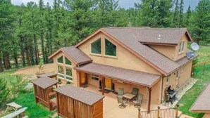 A two-story house with a large deck and a covered patio area. - Remote Cabin Family Fun Hot Tub (Florissant)