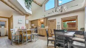 A spacious kitchen with wooden cabinets and a dining area with a table and chairs. - Remote Cabin Family Fun Hot Tub (Florissant)