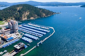 An aerial view of a cruise ship docked at a port with a large number of blue umbrellas, a marina, and a forested island in the background. - The Fairway Home - "3000 sq. ft. Family Friendly Vacation Home w/ Game Room" (Coeur d'Alene)