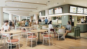 Ein modernes Restaurant mit runden Tischen und Stühlen, einer Theke mit Speisekarte und Gästen, die speisen.