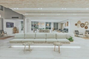 A modern living room with a sofa, two side tables, and a dining area with a table and chairs. - Tanoak Ain Sokhna Hotel (Ataqah)