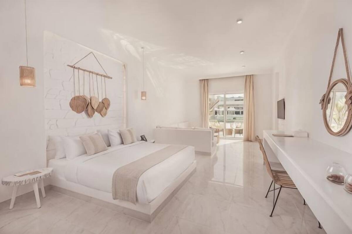 Un dormitorio moderno con cama, mesita de noche y vistas a la ciudad.