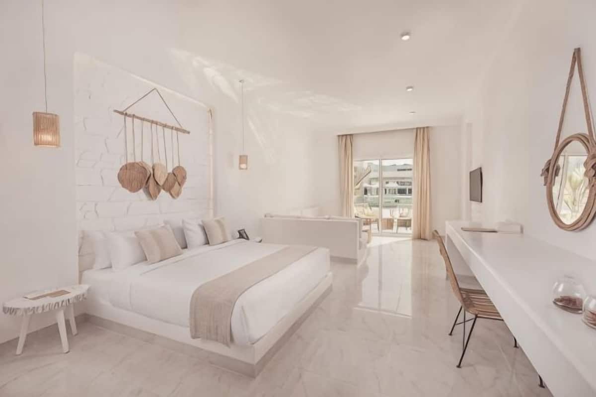 A modern bedroom with a bed, bedside table, and a view of the city.