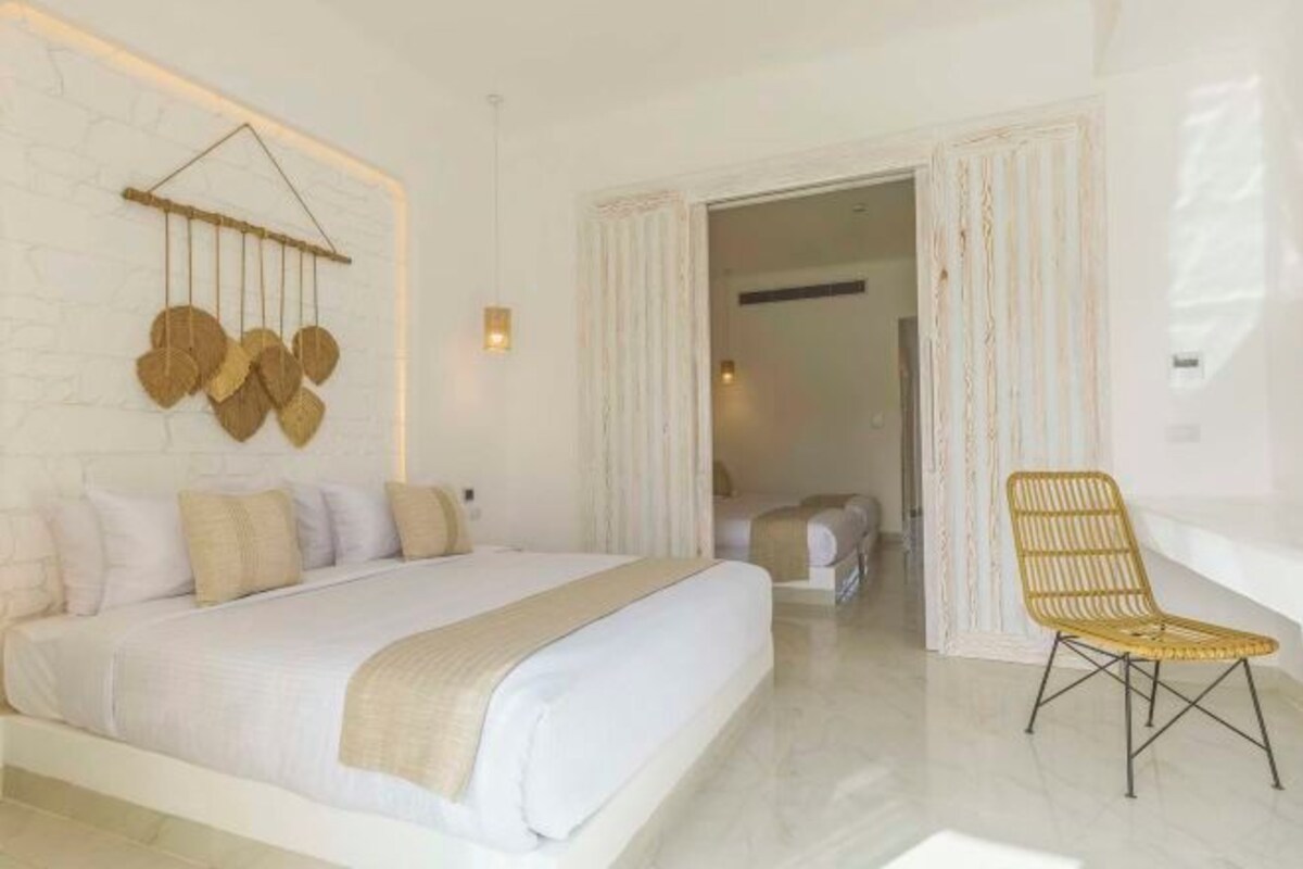 Une chambre à coucher avec un lit, une chaise et un élément de décoration fixé au mur.