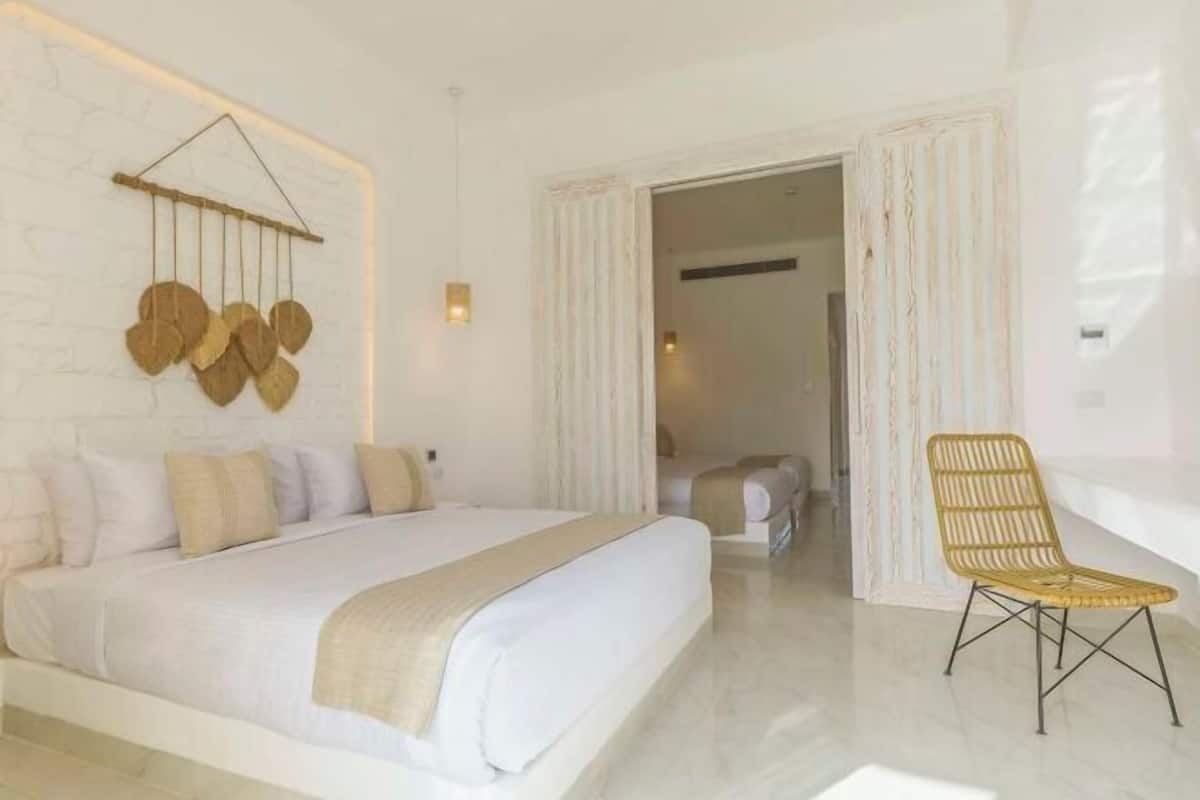 Un dormitorio con cama, una silla y un adorno en la pared.