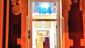 Entrada de hotel com uma placa indicando o número 104 sobre a porta.