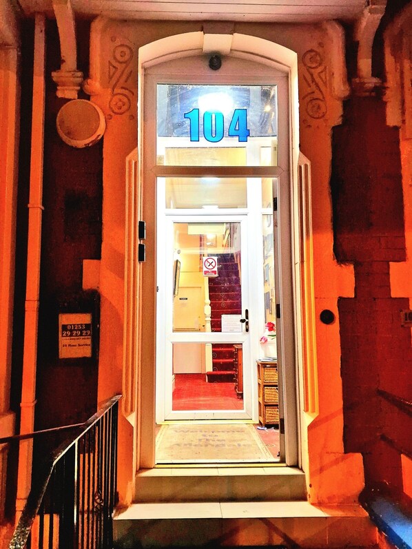 A hotel entrance with a number 104 sign above the door. - Sleep Well Hotel (Blackpool)