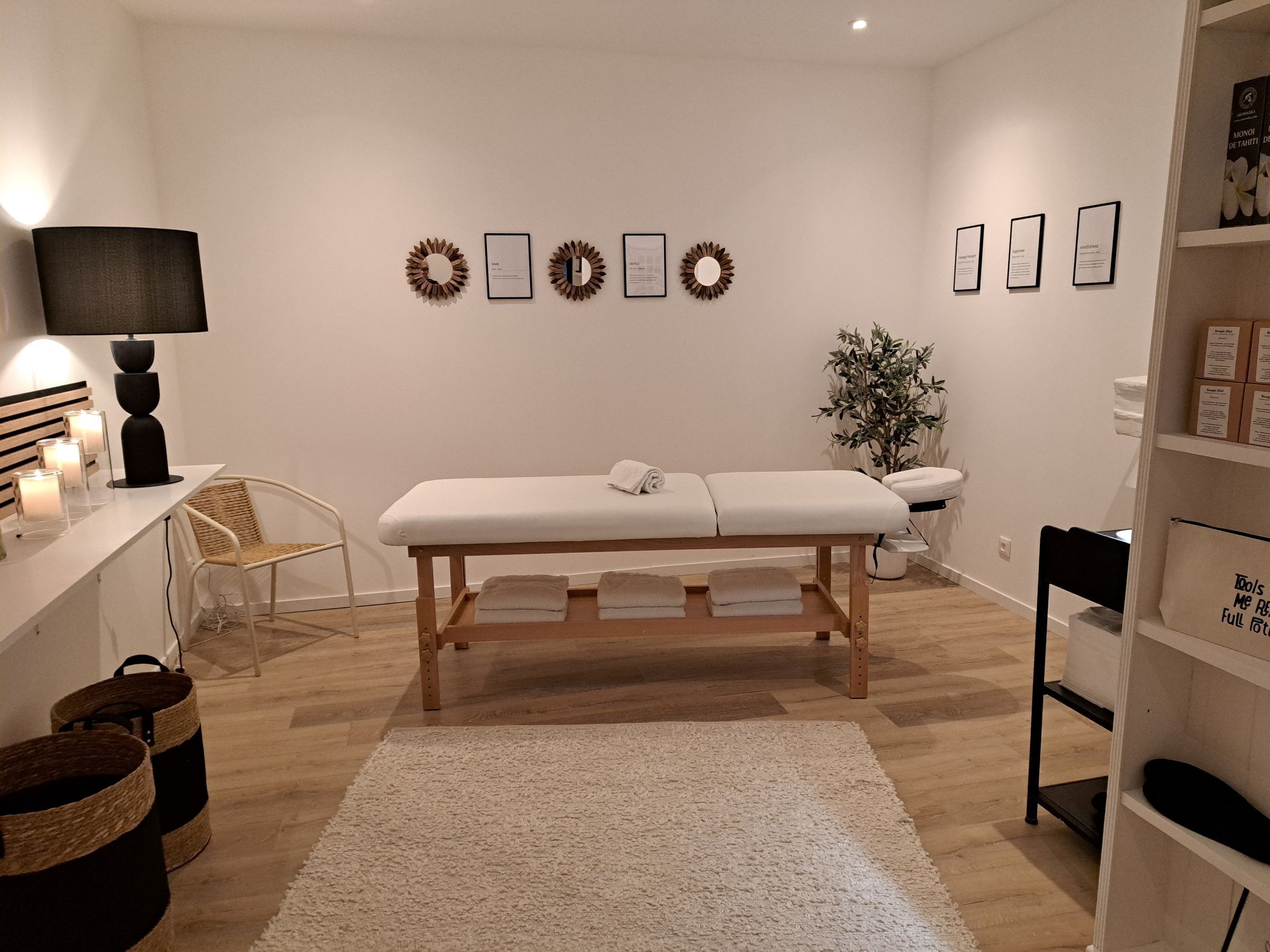 Une pièce propre et moderne, avec un banc en bois, un bureau blanc doté d’une lampe, des chaises en osier et un tapis blanc.