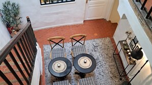 Un comedor con una mesa y sillas, un ventanal pequeño y una escalera.