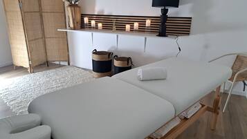 Relax in a serene space with a neatly made bed, a bedside table, and a woven rattan chair.