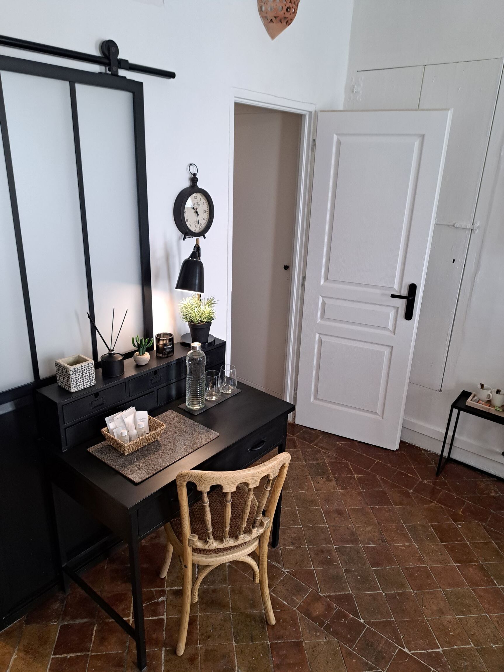 Une pièce avec un bureau, une chaise et une porte blanche.
