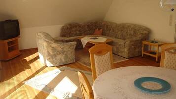 Ein gemütliches Wohnzimmer mit einer Couch, einem Sessel und einem kleinen Tisch.