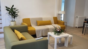 Ein modernes Wohnzimmer mit einem grünen Sofa, einem gelben Sofa und einem weißen Couchtisch.
