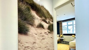 A hallway with a large wall mural of a sandy beach and grass. - Massive New House Sleeps 20+ Accepts Groups (Bournemouth)