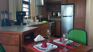 A compact kitchen with a refrigerator, stove, sink, and a blender. - Luxury, affordable, close to town and all of the attractions in the CAYO area... (Santa Elena)