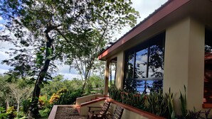 A modern building with a covered outdoor seating area, surrounded by lush greenery and a clear view of the sky. - Luxury, affordable, close to town and all of the attractions in the CAYO area... (Santa Elena)