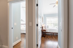 Enjoy a comfortable stay in this airy bedroom with a large window and a ceiling fan.