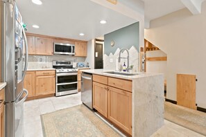 Your fully equipped kitchen features warm wood cabinetry, stainless steel appliances, and a convenient breakfast bar—everything you need to cook up delicious meals during your stay. - Dog Friendly, Spacious Condo, Great Views, Large Deck, East Village, WH405 (Copper Mountain)