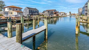 A waterfront property with wooden docks, a calm river, and residential buildings. - NEW LISTING! 15th St Beach Retreat #2 - 2 Bed/1 Bath Waterfront w/ Dock (Ocean City)