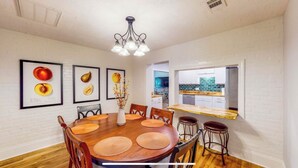 A dining area with a wooden table, six chairs, and a chandelier. There are three framed fruit pictures on the wall. - Cheerful Four Bedroom home conveniently located (Augusta)