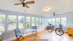 A spacious room with large windows, a ceiling fan, and bicycles. - Cheerful Four Bedroom home conveniently located (Augusta)