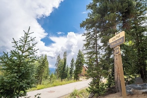 Ein Wegweiser mit der Aufschrift 'Lily Pad Trailhead' und einem Gebäude im Hintergrund.