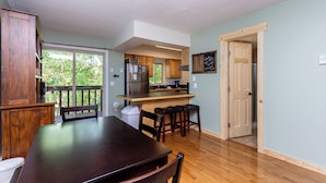 A spacious kitchen with wooden cabinets, a large island, and a sliding glass door leading to a balcony. - Villamont #6916 by Summit County Mountain Retreats (Silverthorne)