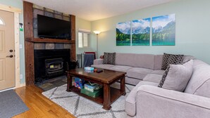 A living room with a fireplace, a sofa, a coffee table, and two paintings on the wall. - Villamont #6916 by Summit County Mountain Retreats (Silverthorne)