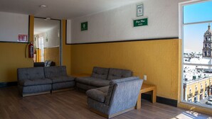 A room with a sofa set, a small table, and a window with a city view.