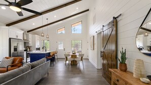 A spacious kitchen with white cabinets, a central island, and a dining area with a round table and chairs.