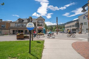A street with a sign for a bike path, buildings, and a clear sky.