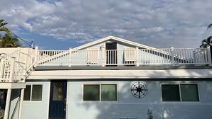 A two-story building with a balcony, a compass symbol on the wall, and a blue door. - Relax in Ocean Ridge-Near Beach (Boynton Beach)