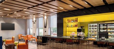 A modern bar area with a wooden ceiling, seating, and a display case with pastries.