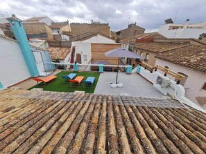 A rooftop terrace with a small lawn, outdoor seating, and a view of surrounding buildings. - Beautiful Town  house. Montserrat, Valencia (Montserrat)