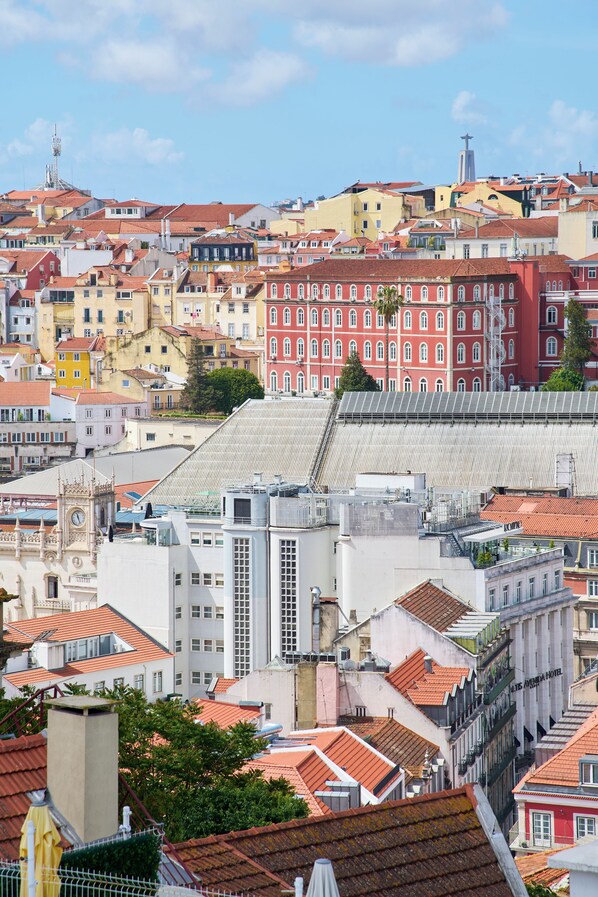 Un paisaje urbano que muestra una mezcla de arquitectura tradicional y moderna, incluyendo un edificio rojo destacado con ventanas arqueadas y un edificio blanco con techo plano.