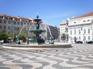 A public square with a central fountain, surrounded by patterned pavement and historic buildings. - New apartment in the historic center (Lisboa)