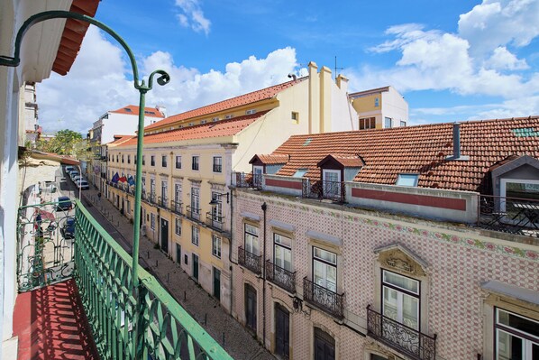 A street view with buildings featuring red-tiled roofs and balconies. - New apartment in the historic center (Lisboa)