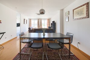 Un comedor con mesa, sillas y alfombra.