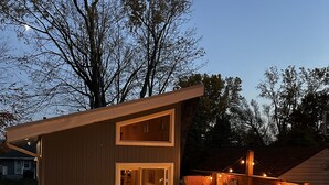 A modern outdoor living space with a fire pit, seating area, and a covered patio.