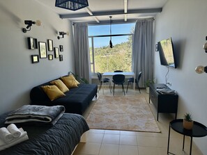 Un dormitorio moderno con sofá, escritorio y televisor.