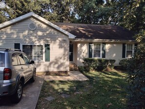 Een gelijkvloers huis met garage, een voortuin en een verzorgd gazon.