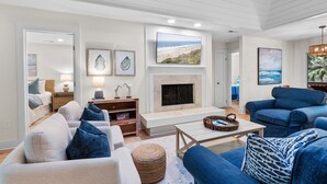 Ein Wohnzimmer mit Kamin, Sofas und Kunstwerken an den Wänden.