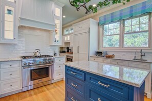 Enjoy cooking in this well-equipped kitchen with a central island, stainless steel range, and double sink.