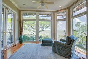 Enjoy a spacious room with a large window offering a view of the outdoors, a comfortable seating area, and a ceiling fan.