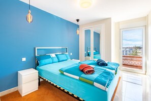 A bedroom with a bed, a nightstand, a mirror, and a view of the outside. - La Nogalera Skyline | Stylish Apartment with Panoramic Sea Views & Pools in Torremolinos (Torremolinos)