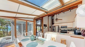 A modern kitchen with white cabinets, a microwave, and a stove.