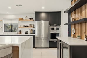 A modern kitchen with a stainless steel refrigerator, built-in oven, and microwave. - Villa Makena: Huge Luxe Home | Pickleball Court | Heated Pool | Great for Groups (Scottsdale)